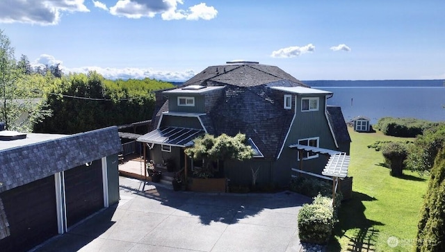 view of home's exterior with a garage, a yard, and a shingled roof