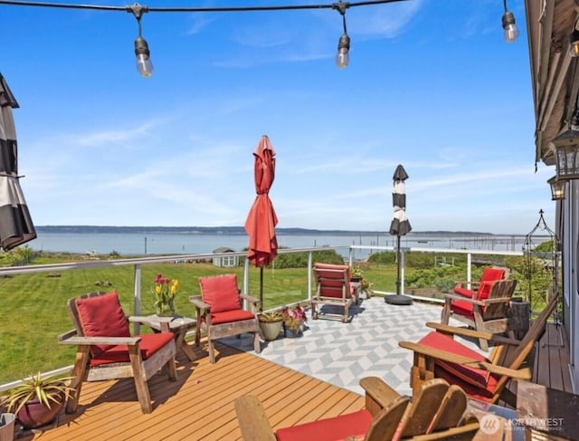 wooden terrace featuring a lawn and a water view