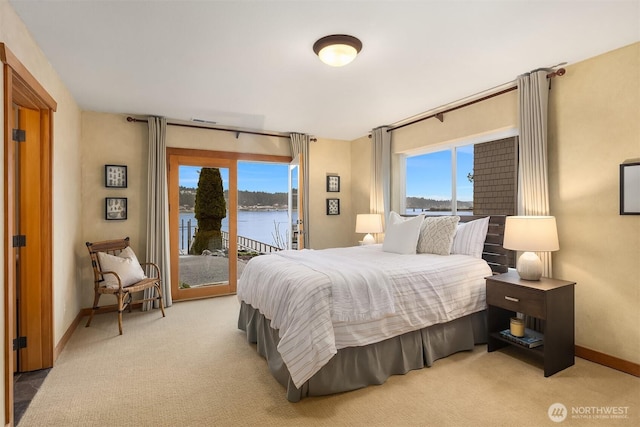 bedroom featuring light carpet, a water view, visible vents, baseboards, and access to exterior