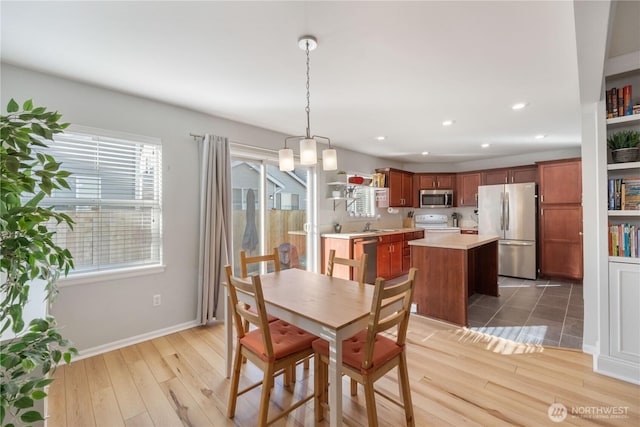 dining room with baseboards, light wood-type flooring, and recessed lighting