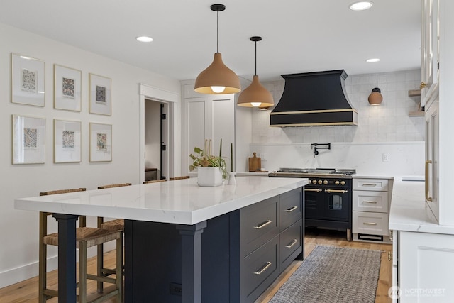 kitchen with range with two ovens, a breakfast bar, recessed lighting, custom range hood, and decorative backsplash