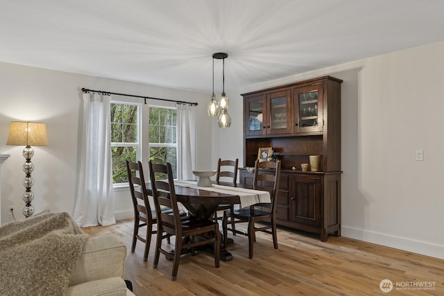 dining area featuring light wood-style flooring and baseboards