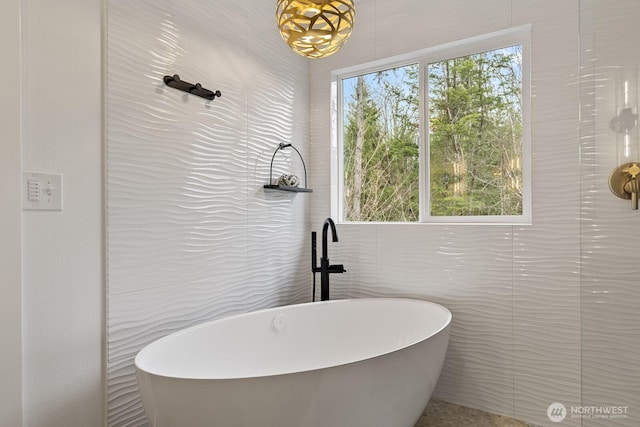 bathroom featuring a soaking tub and tile walls