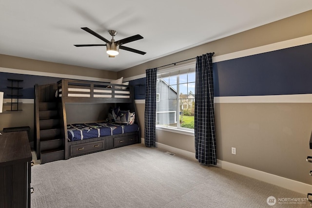 carpeted bedroom with ceiling fan and baseboards