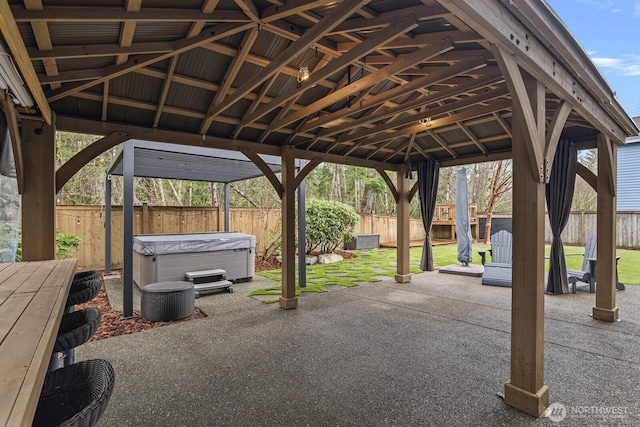 exterior space with a gazebo, a fenced backyard, and a hot tub