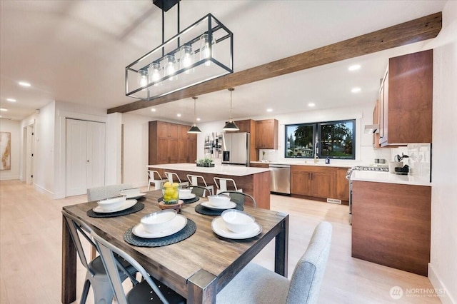 dining space with light wood-type flooring, baseboards, beam ceiling, and recessed lighting