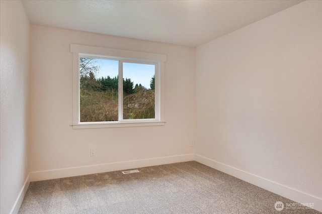 carpeted empty room with visible vents and baseboards