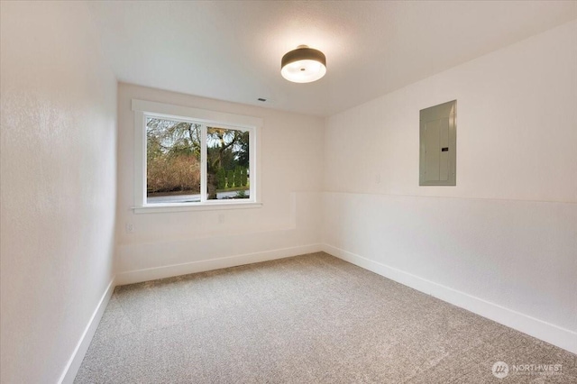 unfurnished room with baseboards, electric panel, and light colored carpet