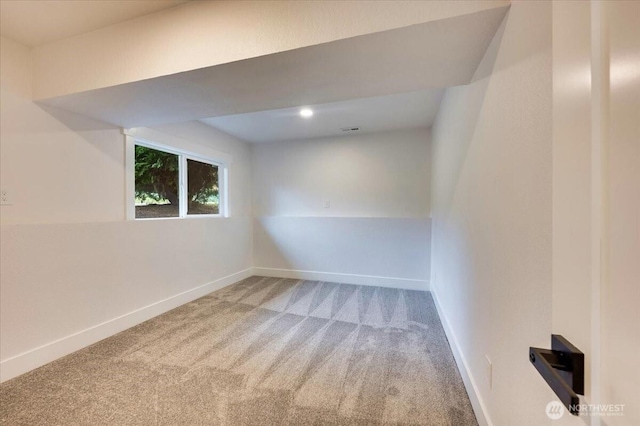 carpeted spare room featuring baseboards