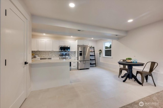 kitchen with recessed lighting, white cabinetry, light countertops, appliances with stainless steel finishes, and backsplash