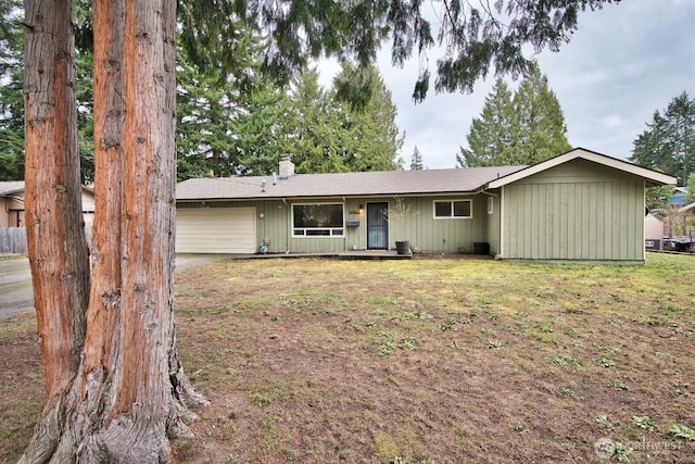 view of front of house with a front lawn, an attached garage, and a chimney