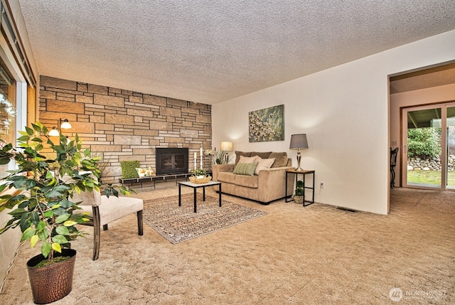 carpeted living room with a stone fireplace and a textured ceiling