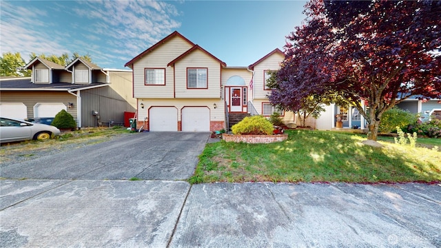 raised ranch with aphalt driveway, a garage, and a front lawn