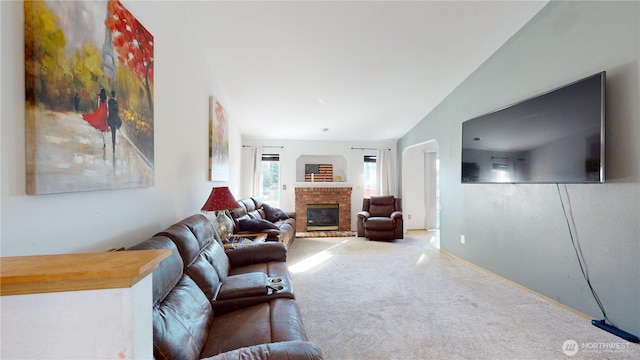 carpeted living room featuring lofted ceiling and a brick fireplace