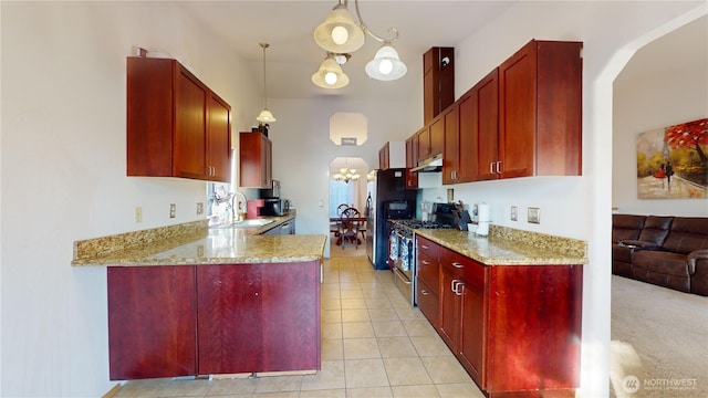 kitchen with stainless steel appliances, a chandelier, under cabinet range hood, and dark brown cabinets