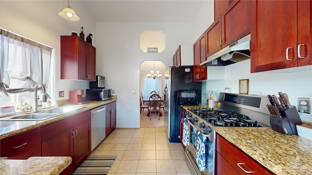 kitchen featuring light tile patterned floors, under cabinet range hood, stainless steel appliances, a sink, and reddish brown cabinets