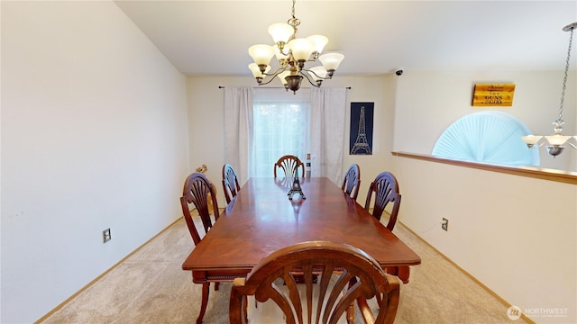 carpeted dining space featuring an inviting chandelier