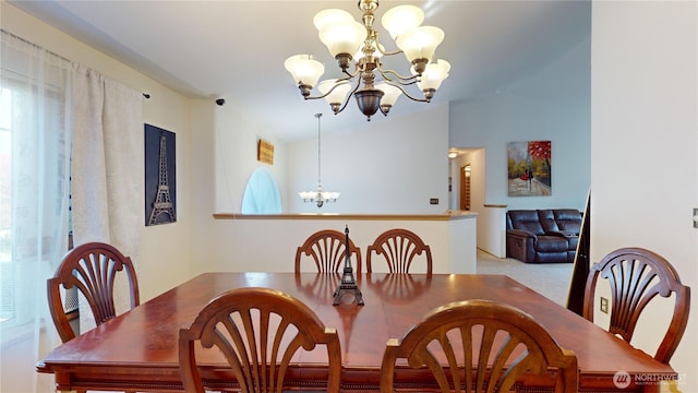 dining room featuring a chandelier, carpet flooring, and vaulted ceiling