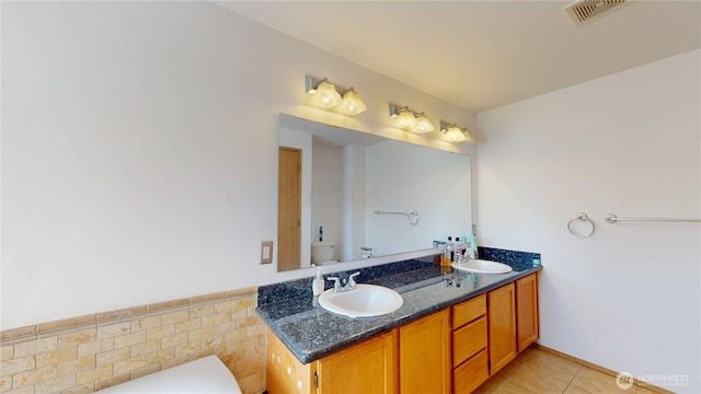 full bath featuring double vanity, visible vents, toilet, tile patterned floors, and a sink