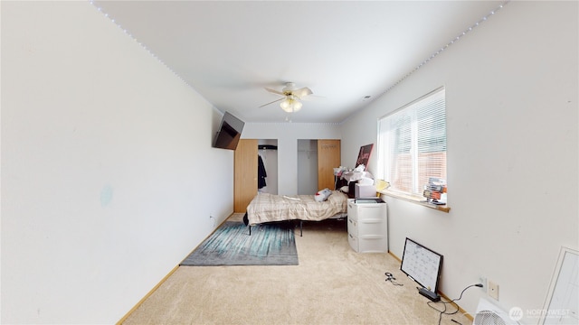 bedroom featuring light carpet and a ceiling fan