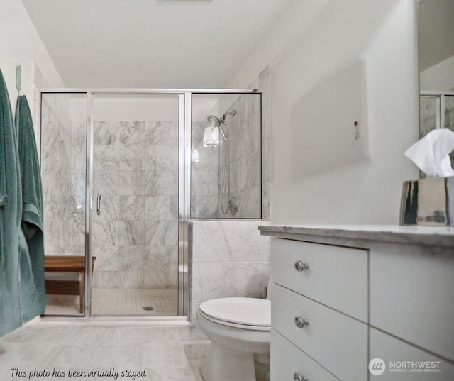 bathroom with a shower stall and toilet