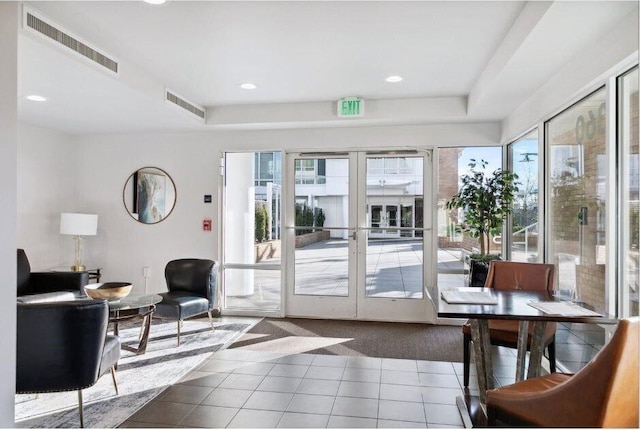 interior space with tile patterned flooring, visible vents, and a healthy amount of sunlight