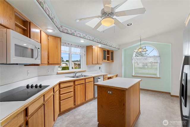 kitchen featuring white microwave, a kitchen island, a sink, stainless steel dishwasher, and black electric stovetop