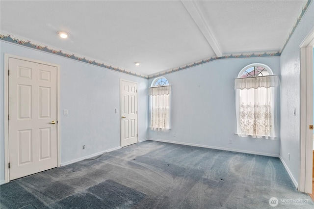 unfurnished room featuring lofted ceiling with beams, baseboards, and carpet floors