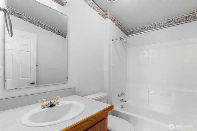 bathroom with shower / tub combination, toilet, and vanity