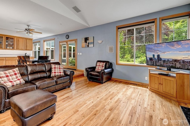 living area with light wood-style floors, a wealth of natural light, french doors, and lofted ceiling