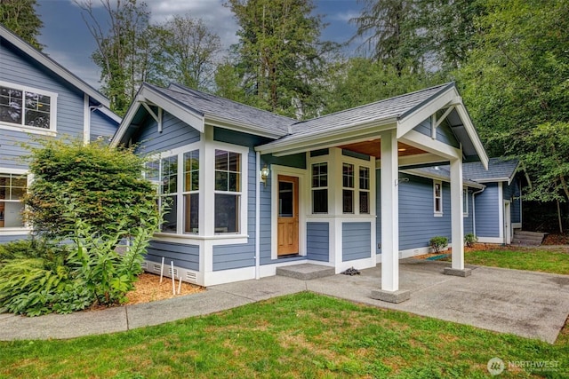 view of front facade with crawl space, a front lawn, and roof with shingles