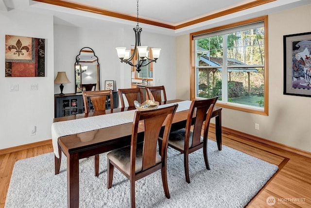 dining room with light wood-style floors, baseboards, and a chandelier