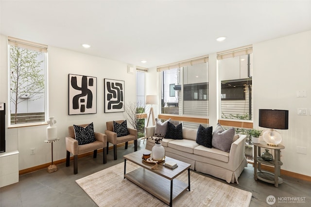 living room with recessed lighting, finished concrete flooring, and baseboards