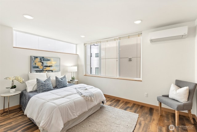 bedroom featuring recessed lighting, baseboards, a wall unit AC, and dark wood-style flooring