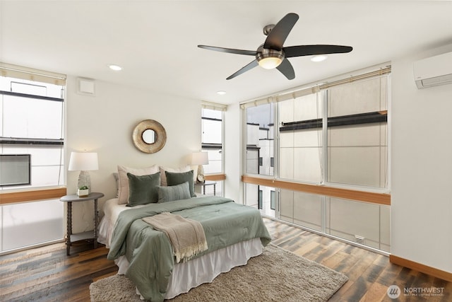 bedroom featuring a wall mounted AC, wood finished floors, recessed lighting, baseboards, and ceiling fan