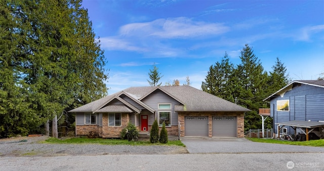 view of front of house with driveway, stone siding, an attached garage, and roof with shingles