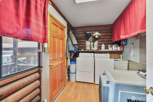 laundry area with log walls, washer and clothes dryer, light wood finished floors, a sink, and laundry area