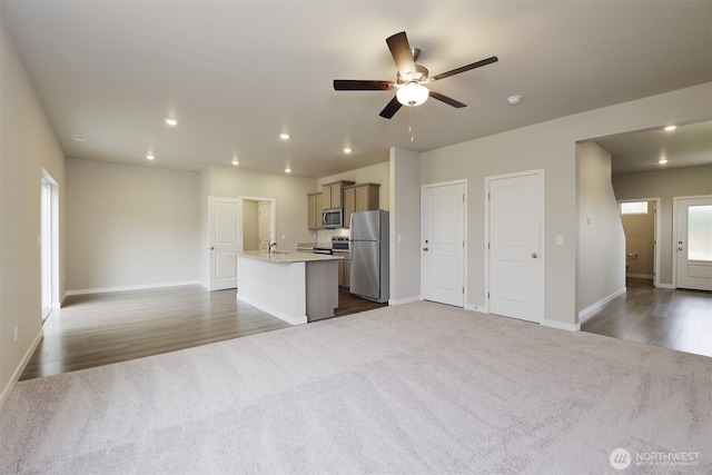 kitchen featuring a kitchen island with sink, recessed lighting, stainless steel appliances, carpet flooring, and open floor plan