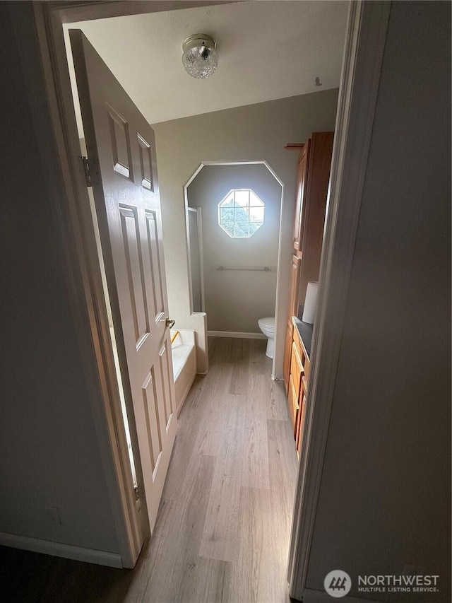 interior space with baseboards and light wood-type flooring