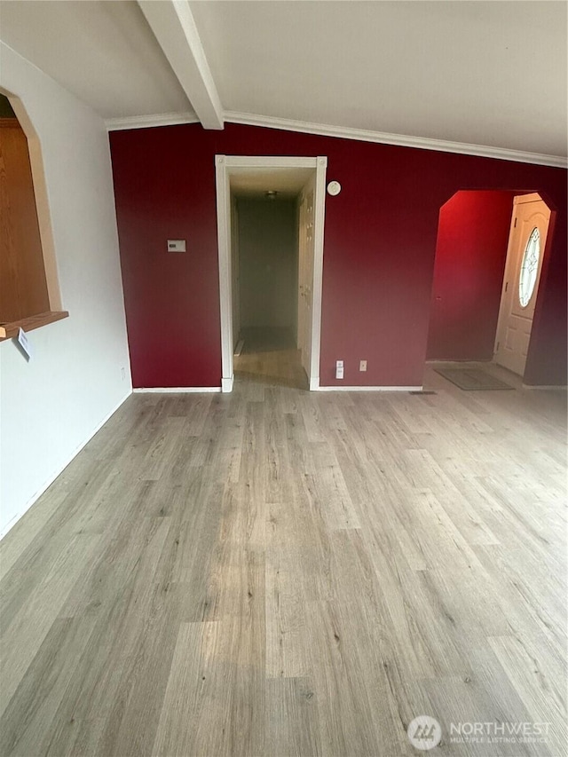 interior space featuring beam ceiling, arched walkways, and wood finished floors