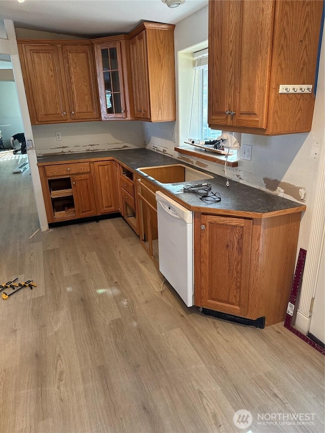 kitchen featuring a sink, brown cabinets, light wood-style flooring, and white dishwasher