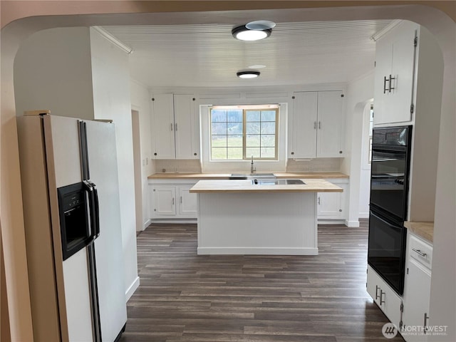 106 Alder St, Pe Ell, WA 98572 - kitchen featuring white fridge with ice dispenser, arched walkways, light countertops, and white cabinets
