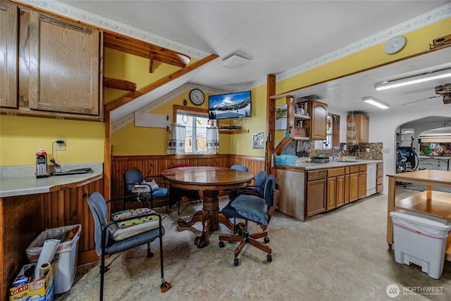 723 E 54th St, Tacoma, WA 98404 - kitchen with brown cabinets, light countertops, wainscoting, and white dishwasher
