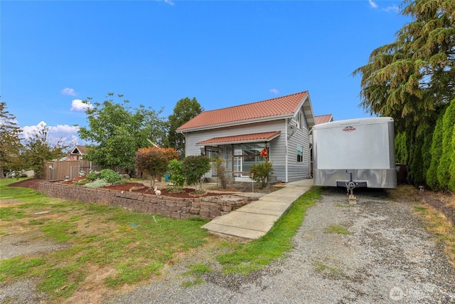 723 E 54th St, Tacoma, WA 98404 - view of front of house with gravel driveway, a tile roof, and fence