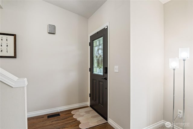 foyer featuring visible vents, baseboards, and wood finished floors