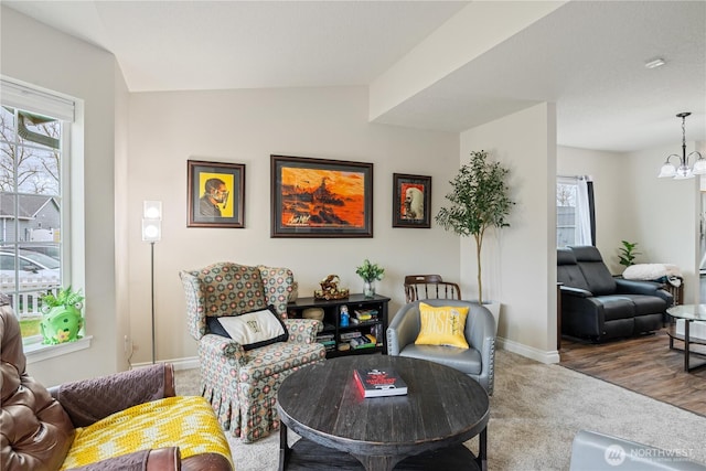 sitting room featuring baseboards, carpet floors, and a notable chandelier