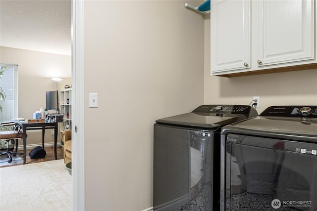 laundry area featuring washer and dryer, cabinet space, and baseboards