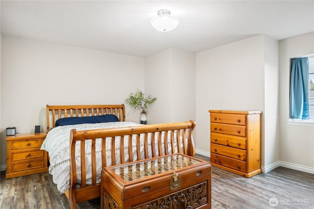 bedroom featuring baseboards and wood finished floors