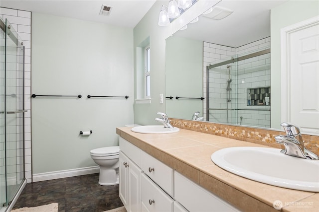 bathroom featuring toilet, a stall shower, a sink, and visible vents