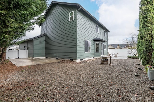 rear view of property with an outdoor fire pit, a gate, a patio, and fence